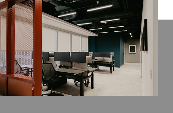 Modern office interior with individual computer workstations, ergonomic chairs, and neutral-toned decor.