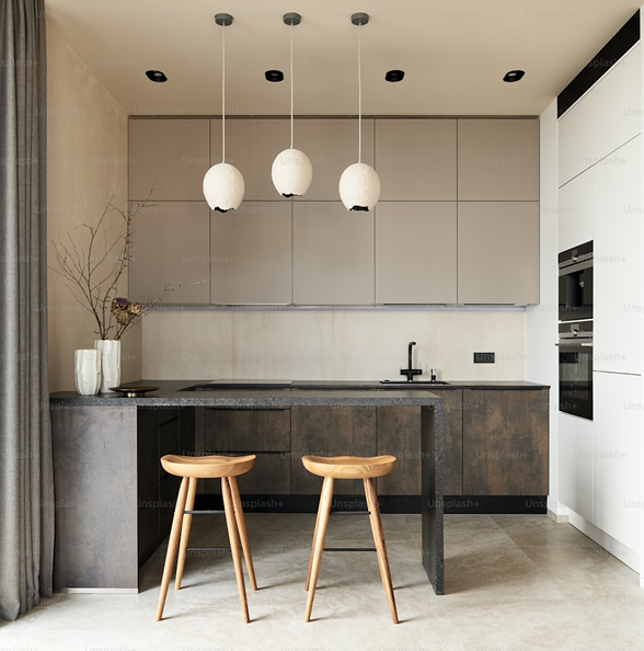 Contemporary kitchen remodel by Becker Services featuring matte cabinetry, black countertops, pendant lighting, and minimalist bar seating.