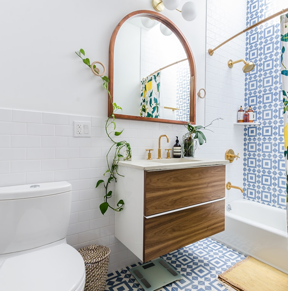 Bathroom renovation with patterned tiles, wood vanity, gold fixtures, and mid-century modern decor by Becker Services.